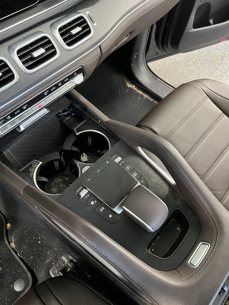 Mittelkonsole eines Mercedes GLE mit Krümeln und Staub in Getränkehaltern und Ablage