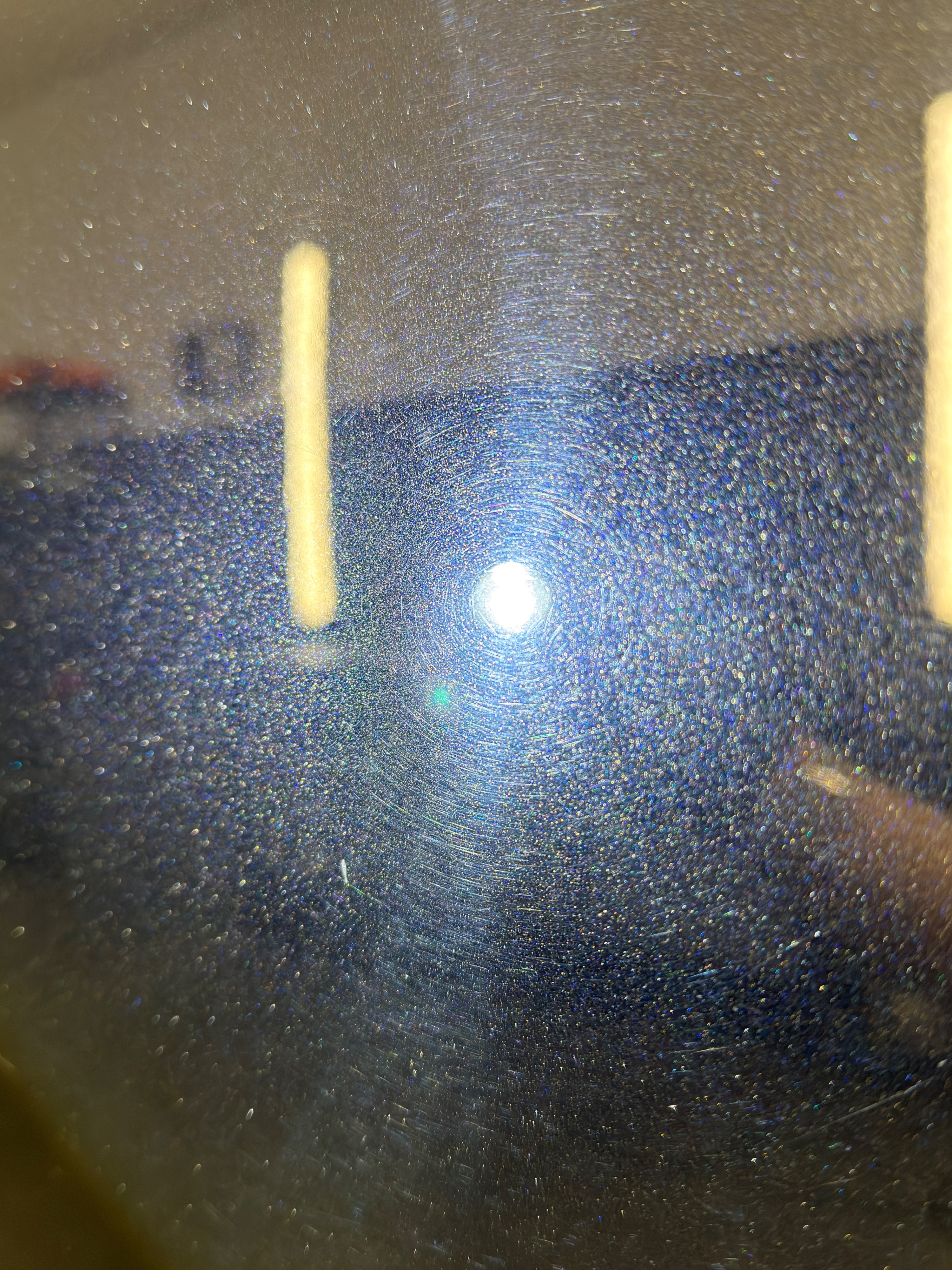 Lackoberfläche vor der mehrstufigen Lackkorrektur unter Politurlampe — deutliche kreisförmige Hologramme und Swirls